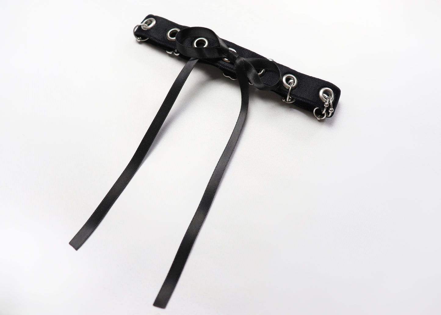 Eyelet and piercing choker decorated with a bow