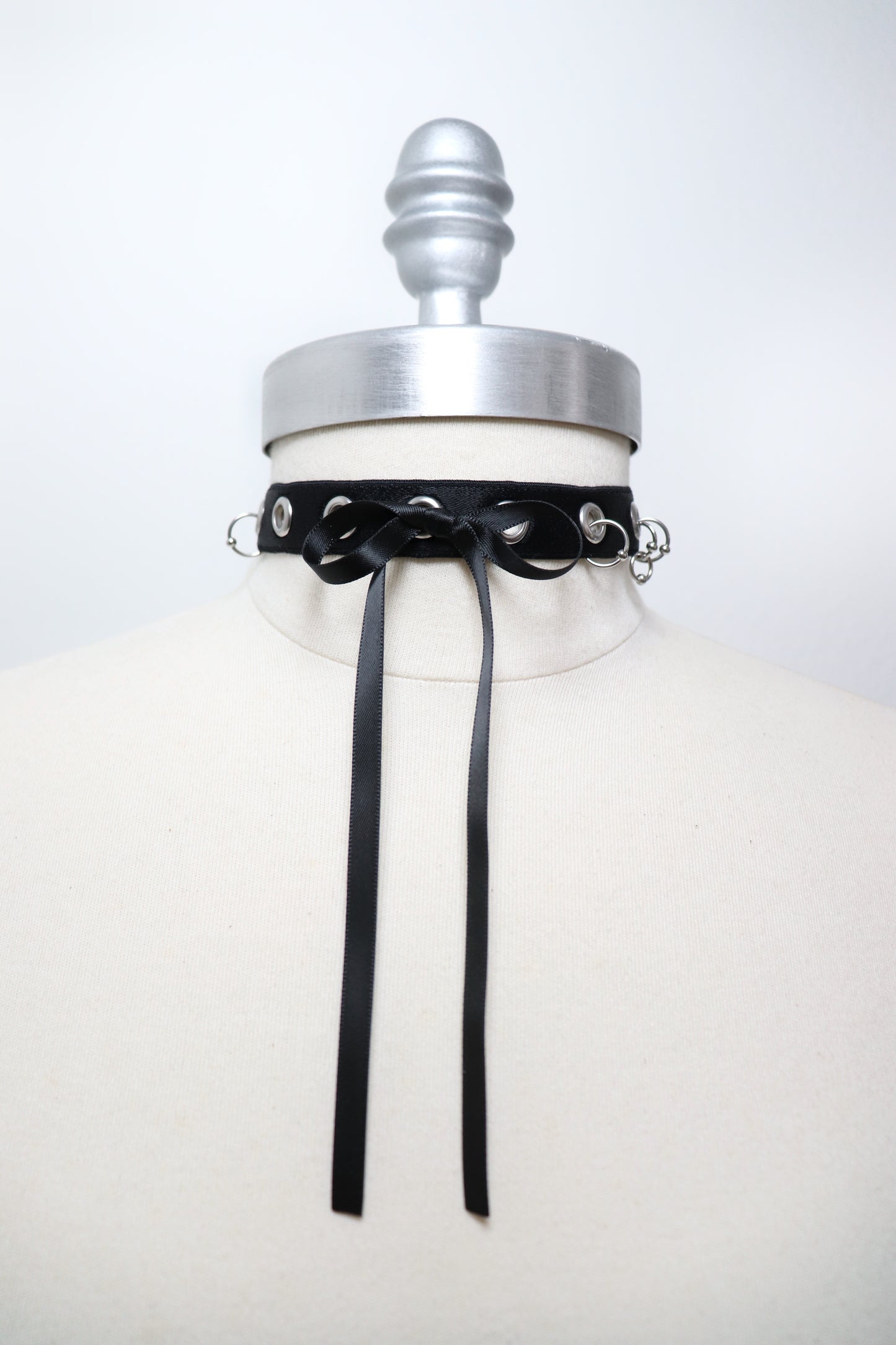 Eyelet and piercing choker decorated with a bow